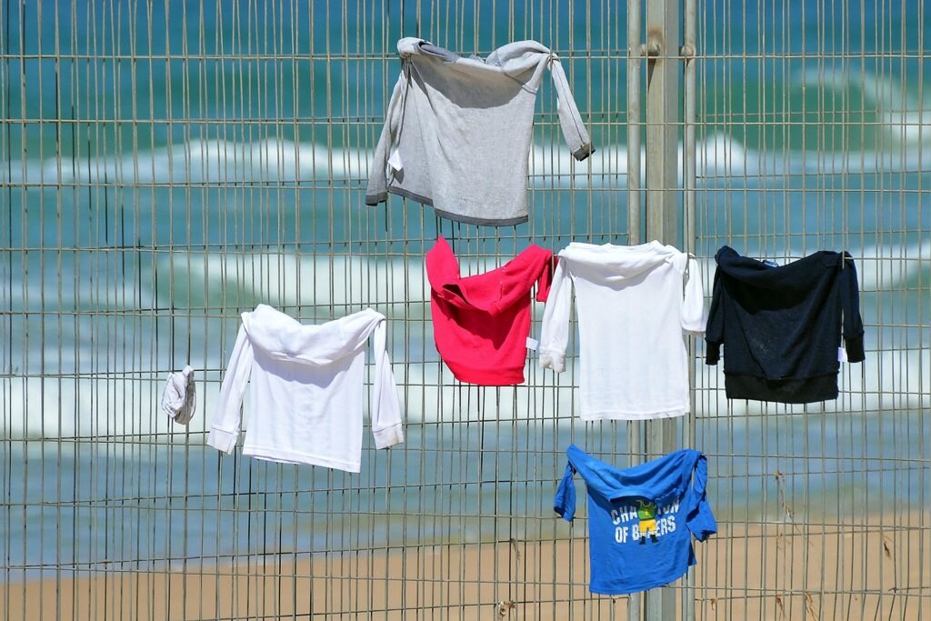 T-shirts hanging on a wire fence